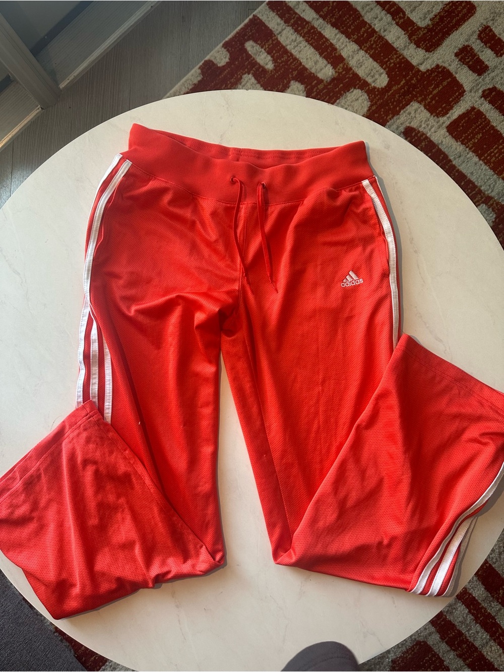 Adidas red track pants with white stripes